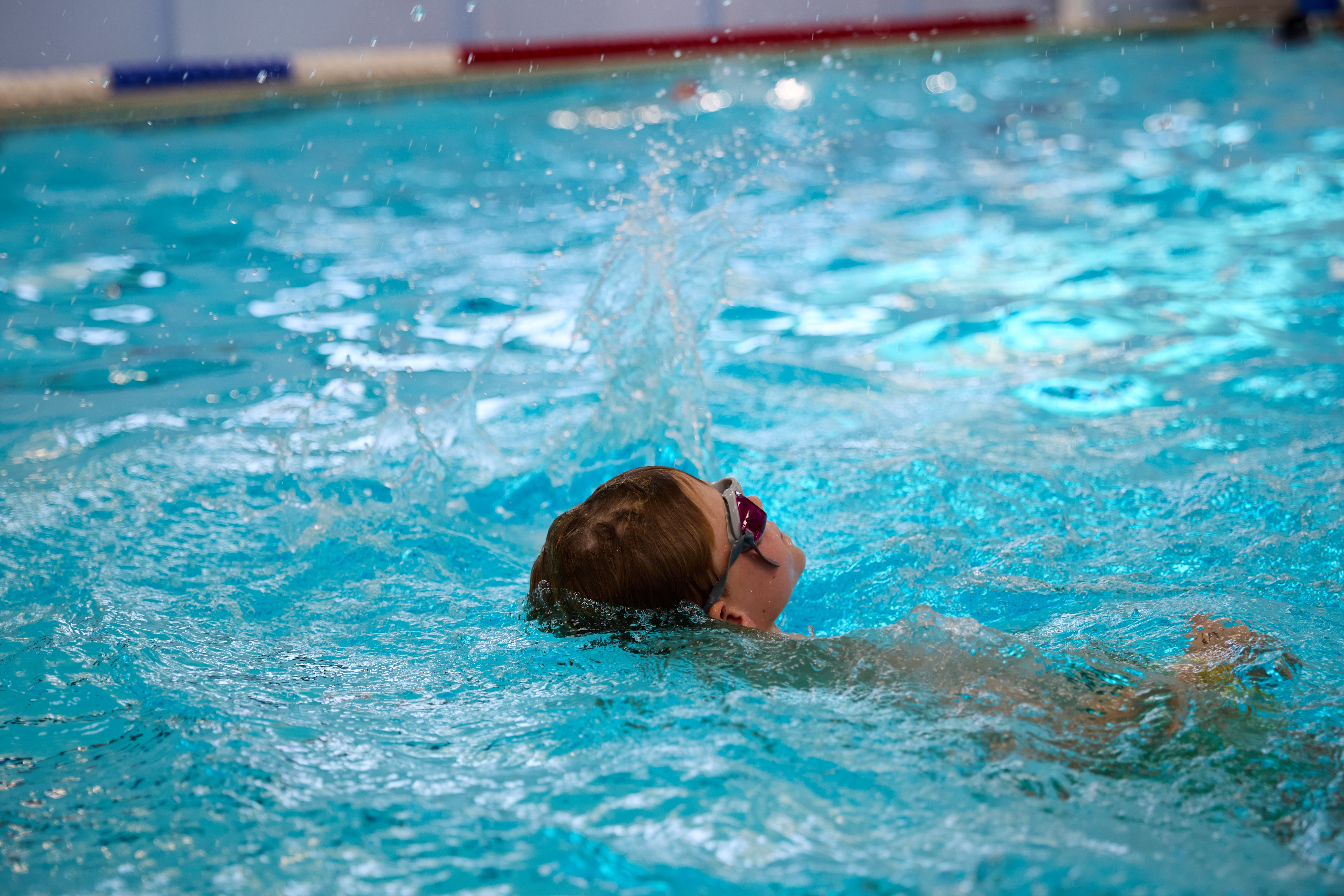 Child swimming on their back in the pool