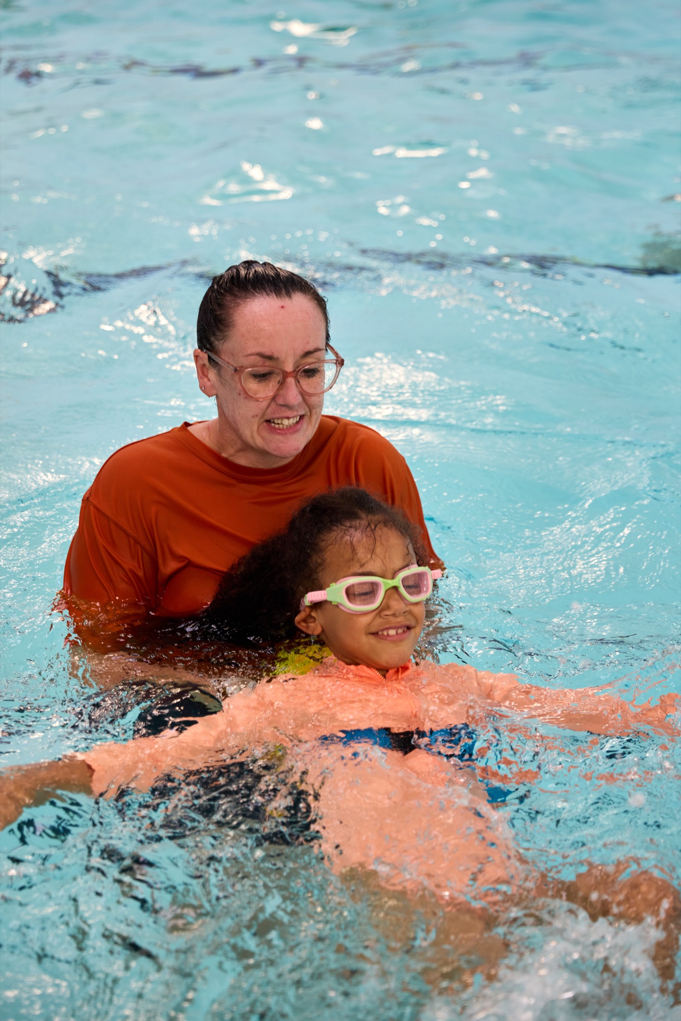 Swim instructor teaching a child to float