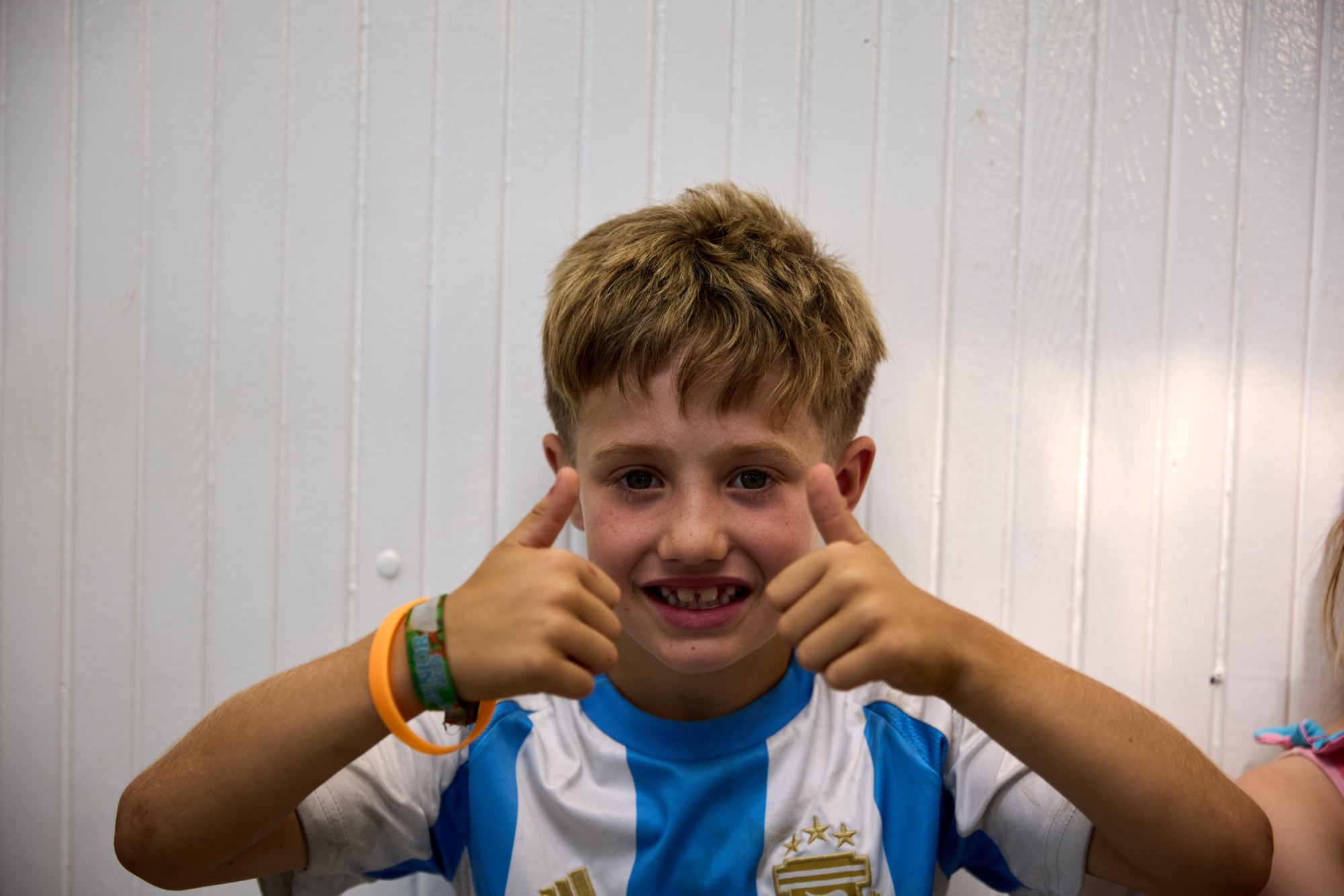 Boy in football shirt giving thumbs up
