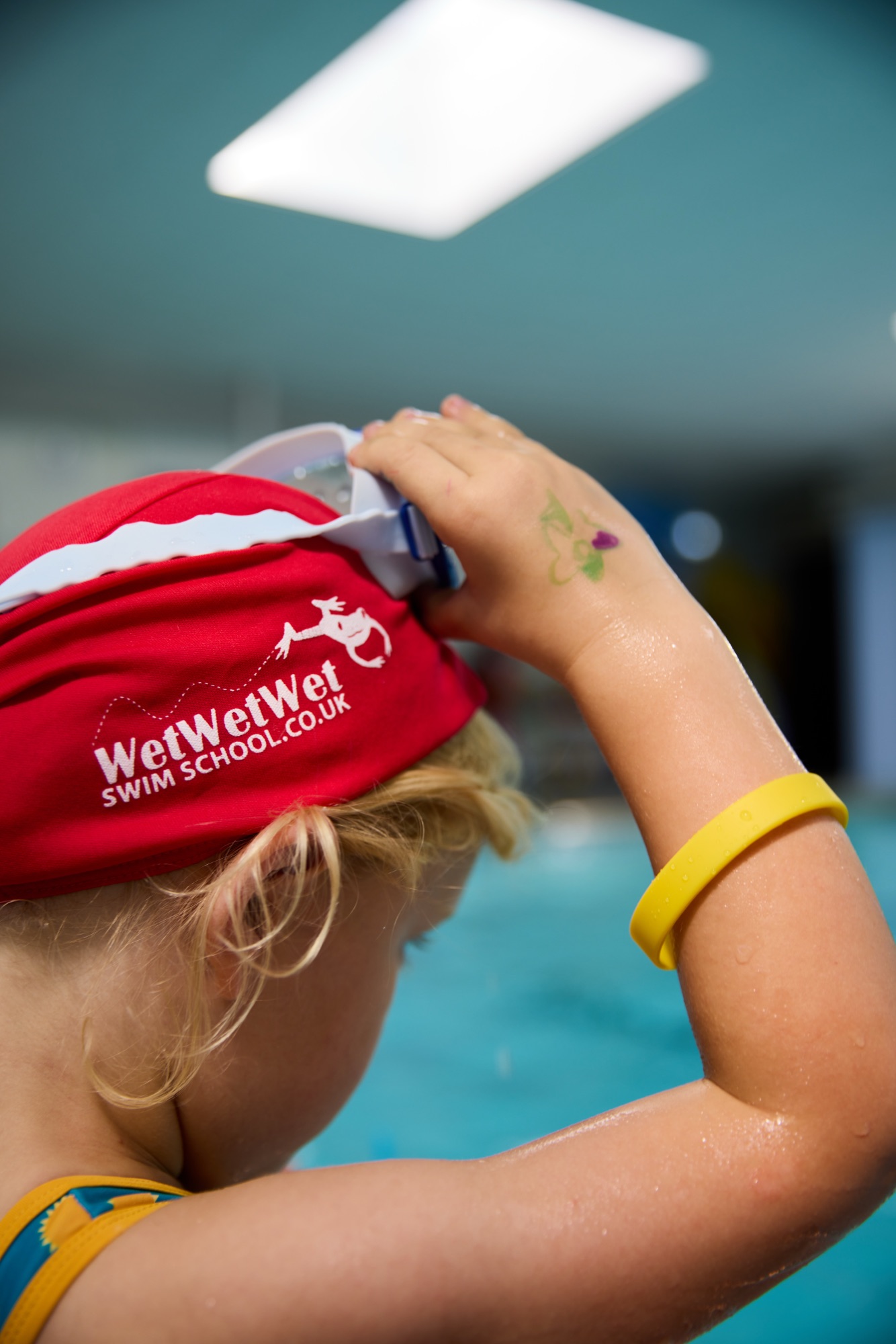 Child adjusting swim goggles